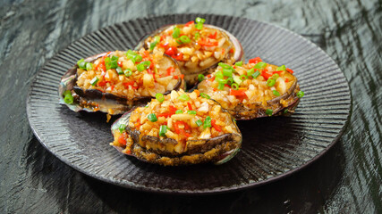 Steamed Abalone with Garlic Showcase - Gourmet Seafood Dish on Black Plate