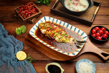 Steamed Grouper Fish with Black Bean Sauce Chinese Cuisine Dish on Wooden Table