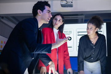 Diverse digital marketing and web development experts intensely discussing UX UI project during a late night brainstorming session. Creative team strategize a new AI application launch at the office