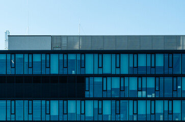 Modern blue glass office facade with repetitive window pattern