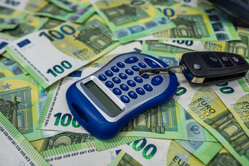 Euro bills with calculator and car key representing vehicle financing, investment and budgeting...