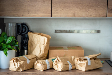 Meal kit ingredients sorted by recipe and placed on the kitchen counter. Concept of convenient grocery delivery for home cooking with pre-portioned ingredients.