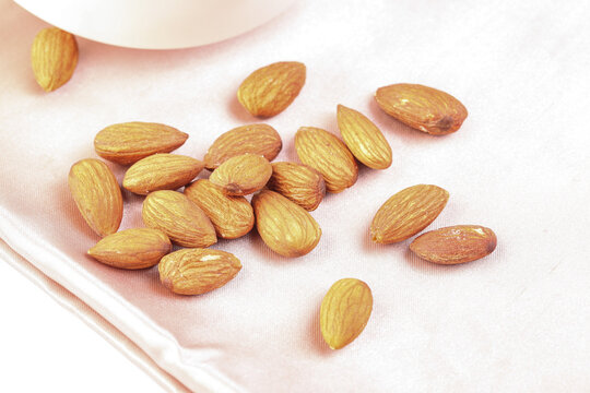 Roasted Almonds in Hand on White Plate - Healthy Nuts Snack