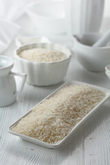 Raw organic rice in white dish.