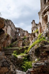 Fototapeta premium Ancient stone ruins with overgrown vegetation and dramatic sky