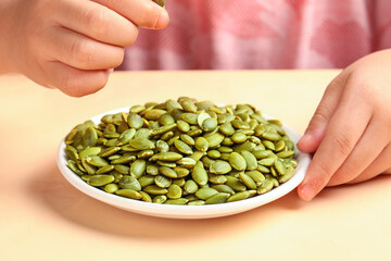 Child Holding Bowl of Shelled Pumpkin Seeds - Healthy Snack Studio Shot