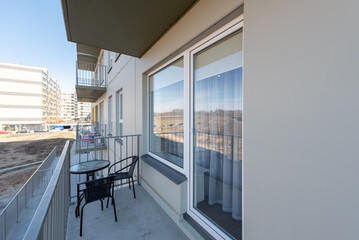 Fototapeta premium Cozy Balcony With Outdoor Seating in a Modern Residential Area