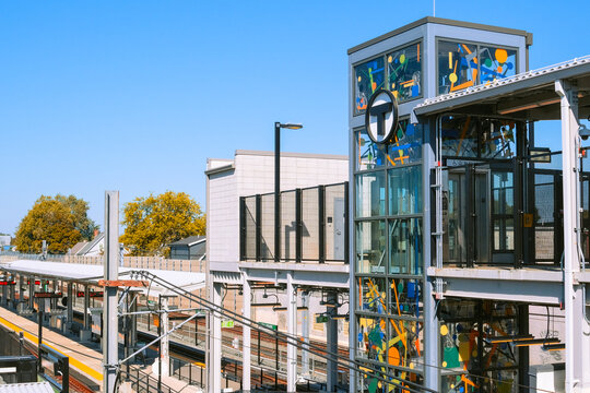 Cambridge, USA - 5 October 2025. Cambridge, USA - 5 October 2025. MBTA green line modern urban train station with glass elevator tower and colorful artwork, tracks and passenger platforms under clear 