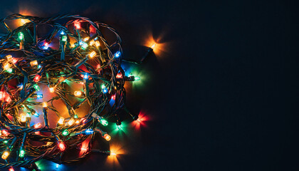Colorful tangled Christmas string lights glowing brightly on a dark background, creating a festive and warm atmosphere.