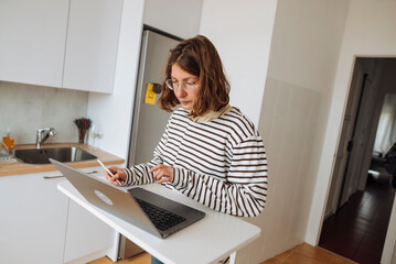 Professional woman conducting online conference from kitchen