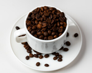 RICH DARK ROAST COFFEE BEANS FILLING WHITE CUP ON SAUCER