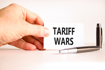 Trade tariff wars symbol. Concept word Tariff wars on beautiful white card. Beautiful black pen. Beautiful white paper background. Businessman's hand. Business trade tariff wars concept. Copy space.