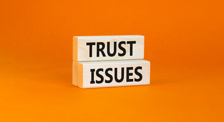 Trust issues symbol. Concept word Trust issues on beautiful wooden blocks. Beautiful orange paper background. Business trust issues concept. Copy space.