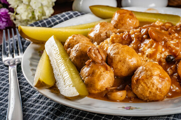 Chicken meatballs  and mushrooms gravy served with groats bulgur and pickled cucumber.