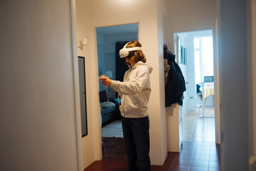 Individual performing virtual reality workout in apartment corridor