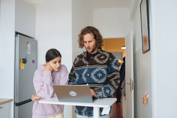 Father assisting young girl with homework in cozy kitchen setting