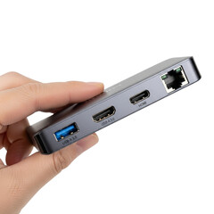 Hand holding a small multiport adapter with usb and ethernet ports isolated on transparent background