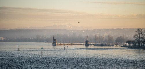 Lake Constance and Constance Harbor with snow-covered S&auml;ntis mountain in the background during a pastel-colored winter evening. Konstanz, Baden-W&uuml;rttemberg, Germany.
