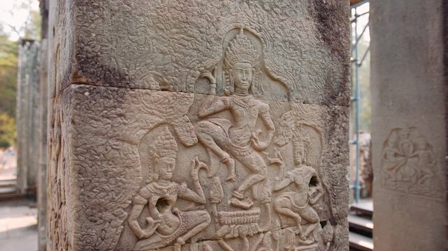 Stone pillar with bas relief carvings of traditional apsara dancers at the historic bayon temple in angkor thom, Cambodia. Archeology concept.