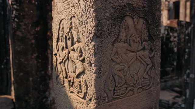 Ancient stone bas relief carving of traditional apsara dancers on a pillar. Detailed historic khmer art at the bayon temple in cambodia. Archeology concept.