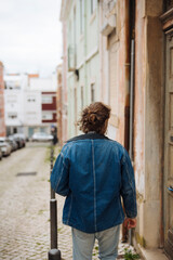 Fototapeta premium Someone wearing jacket wanders through historic cobbled streets