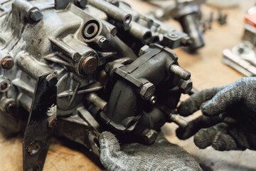 Disassembled old car gearbox with gears in an auto service garage. Repair, maintenance, and replacement of worn mechanical transmission parts in a vehicle
