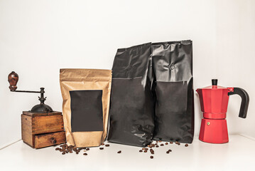A still life with coffee, grinders, bags of coffee beans and a coffee maker