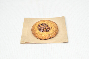 Oatmeal raisin cookie with whole rolled oats and rum-soaked raisins, sprinkled with cinnamon and served warm
