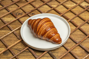A selection of croissants, including plain, almond, and chocolate varieties, arranged in a bread basket with a linen napkin