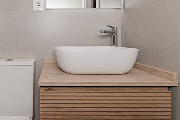 Contemporary bathroom with a tall matte white storage unit, porcelain sink, and recessed  mirror