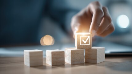 Hand placing checkmark on wooden block