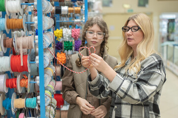 A mother and her teenage daughter in a craft store.