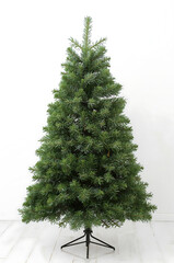 Elegant artificial Christmas fir tree with lush matte green foliage on white background