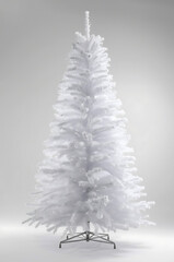 Majestic white artificial Christmas tree with snowflake details on clean backdrop