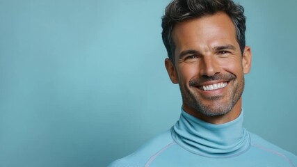 Video A smiling man wearing a blue turtle neck sweater, perfect for casual occasions