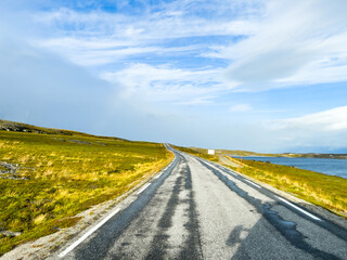Scenic route winding along a lake in a mountainous landscape with autumn foliage