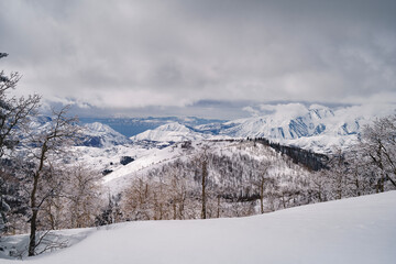 Obraz premium The Uinta and Wasatch Back Mountain Range with white snow covered mountain peaks icy trees and cloudy skies 
