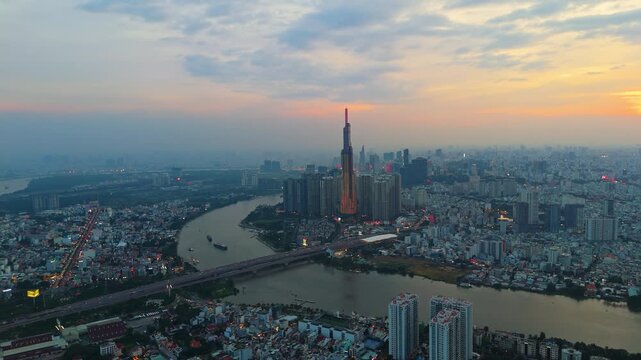 Aerial view of Landmark 81 skyscraper at sunset in Ho Chi Minh City with Saigon River curving through the skyline.