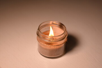 Horizontal candle on a light table, photographed slightly from above and side.