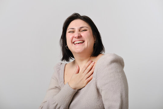 close up shot of an Adult woman laughing heartily with hand on chest