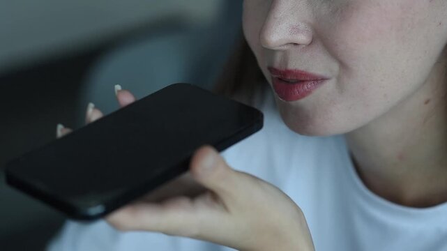 young beautiful caucasian brunette woman recording voice message, smiling widely, casual clothes, white T-shirt, talking by smartphone