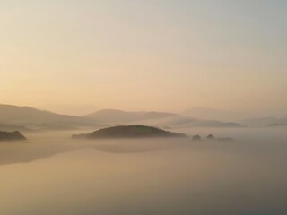 Misty Sunrise Over Calm Hills Landscape