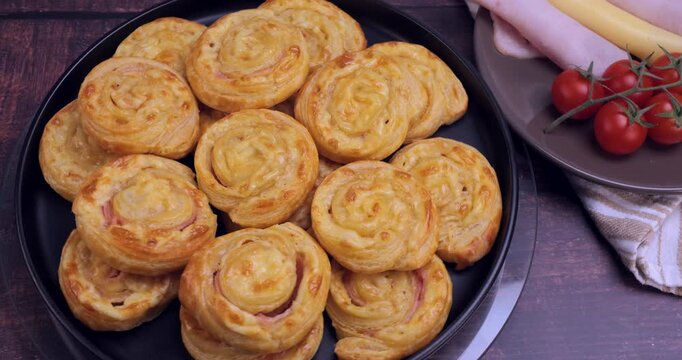 Golden puff pastries filled with ham and melted cheese. Crispy, flaky texture perfect for showcasing baking, snack preparation, cooking tutorials and delicious food content. 4k