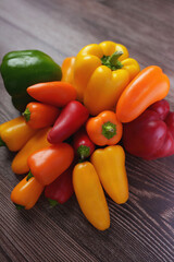 a vibrant assortment of colorful bell peppers arranged on a textured wooden surface, showcasing varying hues and shapes with vivid contrast and natural freshness, aesthetic, appealing, lush