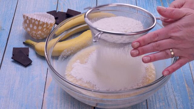 Close-up shot of flour being sifted over dough, creating a soft dusting and highlighting the baking process. Ideal for cooking tutorials, recipe videos, bakery content and culinary demonstrations.