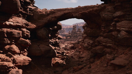 Bright sunlight illuminates the rugged landscape, highlighting the stunning red rock formations and a natural arch. A sense of adventure fills the air as the canyon stretches into the distance.
