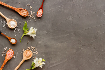 Obraz na płótnie Canvas Beauty spa therapy cosmetics and wellness flat lay - sea salt in many spoons with flowers, top view