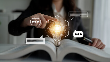 A woman points at a glowing light bulb surrounded by chat bubbles over an open book, representing innovative ideas and effective communication in a contemporary workspace. Gantry