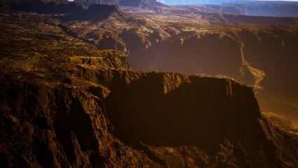 Under the soft glow of dusk, deep canyons reveal their rugged beauty. Shadows dance across the cliffs, showcasing the dramatic landscape of this serene natural wonder.