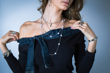 Young girl trying on a knitted sweater against a blue wall